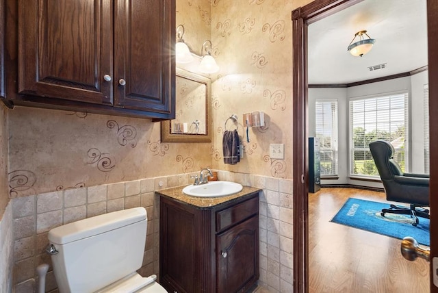 5420 NE 56th St, Oklahoma City, OK 73121 - bathroom featuring vanity, tile walls, wainscoting, ornamental molding, and wallpapered walls