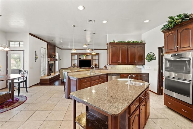 5420 NE 56th St, Oklahoma City, OK 73121 - kitchen with stainless steel appliances, open floor plan, light tile patterned floors, a fireplace with raised hearth, and recessed lighting