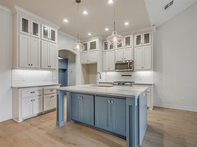 8408 NW 134th St, Oklahoma City, OK 73142 - kitchen featuring stainless steel microwave, backsplash, white cabinets, arched walkways, and recessed lighting