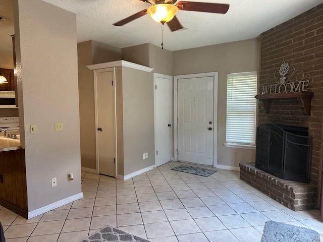 1208 SW 21st St, Oklahoma City, OK 73170 - foyer with ceiling fan, light tile patterned flooring, and a brick fireplace
