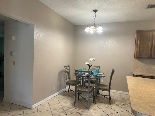 1208 SW 21st St, Oklahoma City, OK 73170 - dining room featuring a chandelier, a textured ceiling, and light tile patterned flooring