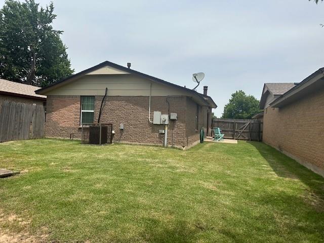 1208 SW 21st St, Oklahoma City, OK 73170 - back of property with a fenced backyard and brick siding