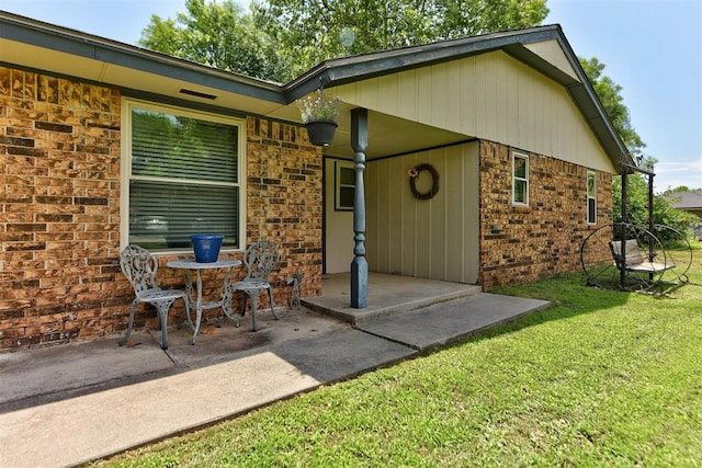 881 County St Unit 2938, Tuttle, OK 73089 - property entrance featuring a lawn, brick siding, and a patio area