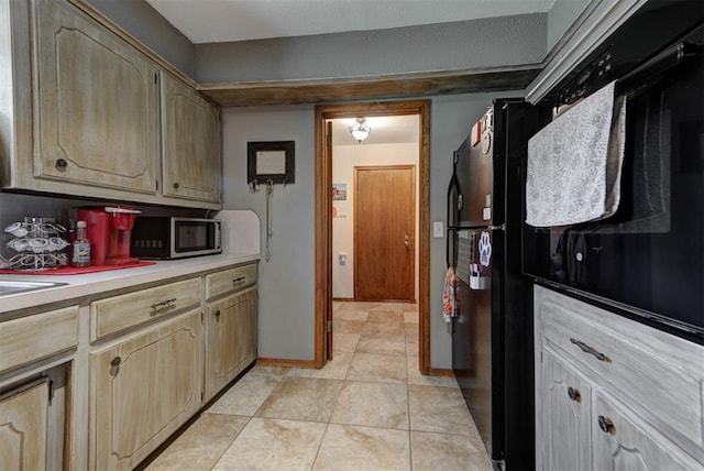881 County St Unit 2938, Tuttle, OK 73089 - kitchen featuring stainless steel microwave, light countertops, light tile patterned floors, and freestanding refrigerator