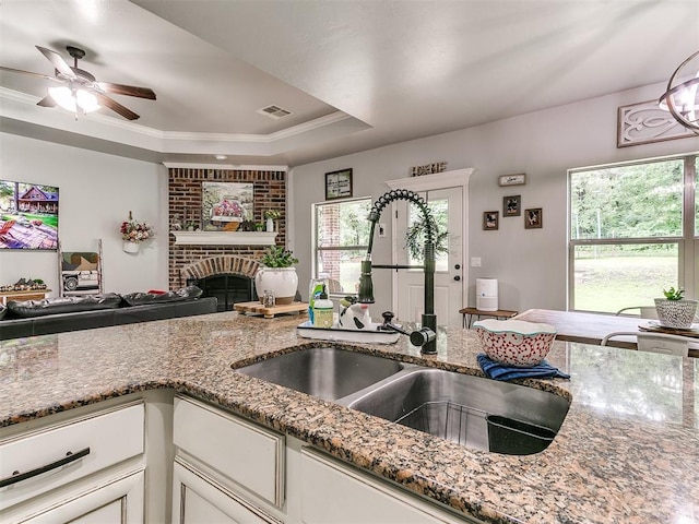 21945 N Fork Rd, Luther, OK 73054 - kitchen with open floor plan, stone counters, a ceiling fan, a raised ceiling, and white cabinets