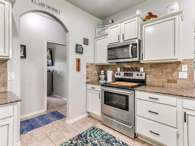 21945 N Fork Rd, Luther, OK 73054 - kitchen with stainless steel appliances, arched walkways, tasteful backsplash, and light stone countertops