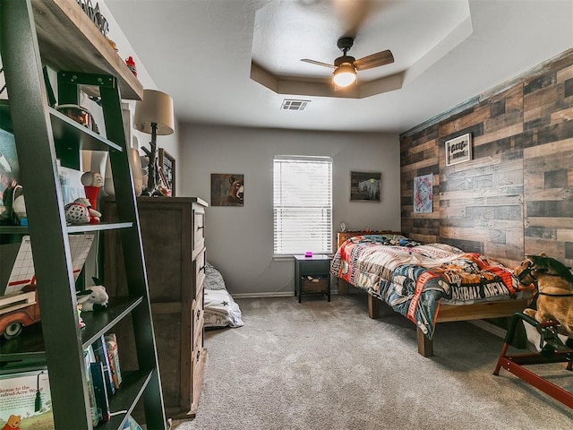 21945 N Fork Rd, Luther, OK 73054 - carpeted bedroom featuring wood walls, a ceiling fan, and a tray ceiling