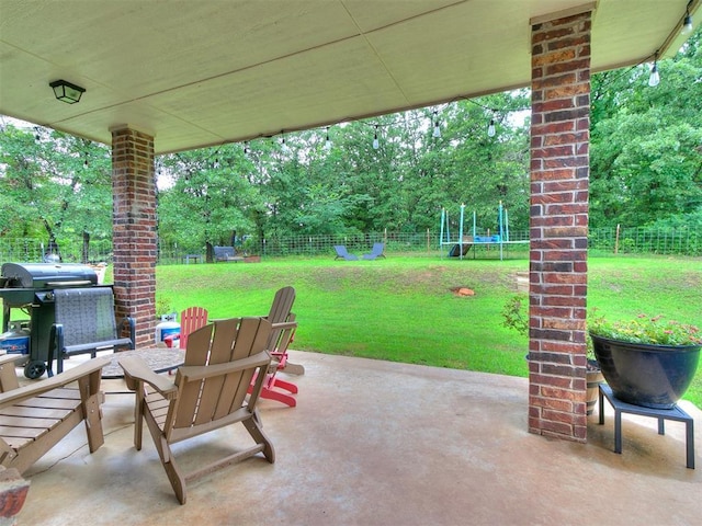 21945 N Fork Rd, Luther, OK 73054 - fenced backyard featuring a trampoline, a patio area, area for grilling, and view of wooded area