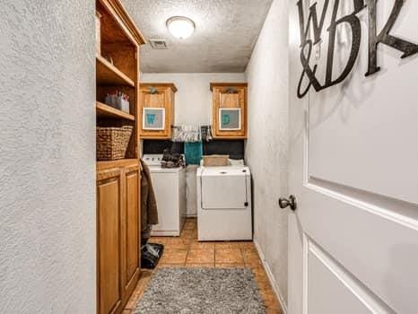 23 Lake Ln, Shawnee, OK 74804 - washroom featuring a textured wall, a textured ceiling, washing machine and clothes dryer, and light tile patterned flooring
