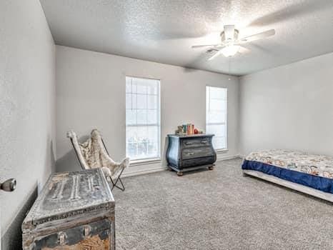 23 Lake Ln, Shawnee, OK 74804 - bedroom with a textured ceiling, carpet flooring, and ceiling fan
