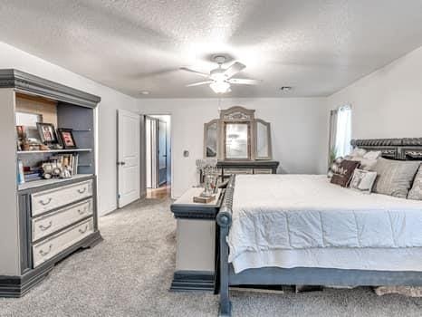 23 Lake Ln, Shawnee, OK 74804 - carpeted bedroom with a textured ceiling and a ceiling fan