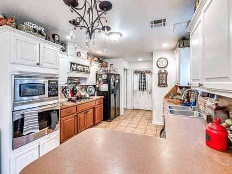 23 Lake Ln, Shawnee, OK 74804 - kitchen with appliances with stainless steel finishes, light countertops, a chandelier, white cabinets, and recessed lighting