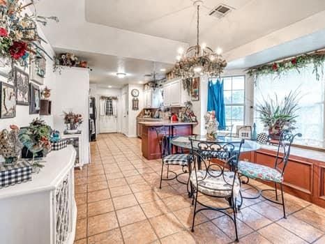 23 Lake Ln, Shawnee, OK 74804 - dining space with light tile patterned floors and a chandelier