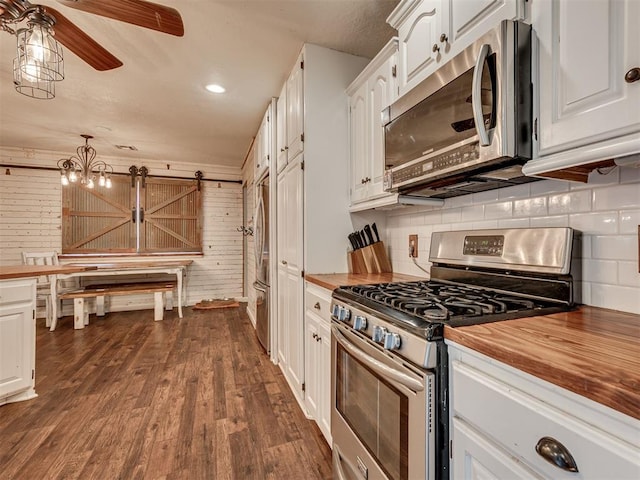 434 N Oak Ave, Hennessey, OK 73742 - kitchen with appliances with stainless steel finishes, butcher block countertops, white cabinetry, backsplash, and wood walls