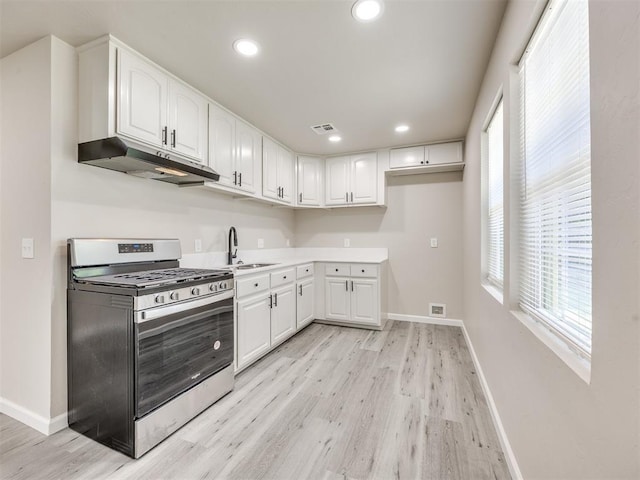3609 S Quapah Ave, Oklahoma City, OK 73119 - kitchen with gas stove, under cabinet range hood, light wood-type flooring, white cabinetry, and recessed lighting