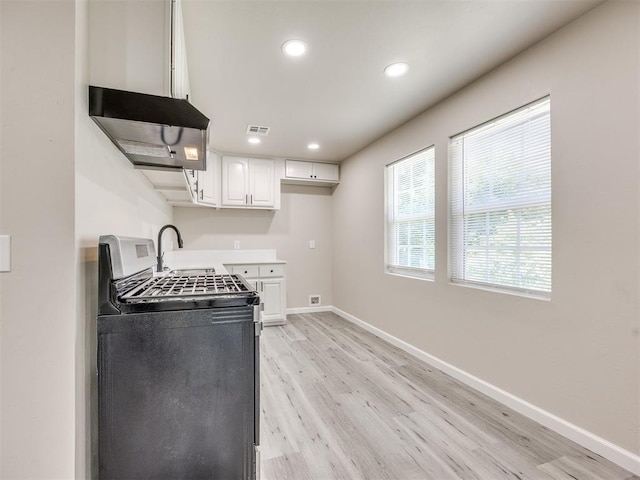 3609 S Quapah Ave, Oklahoma City, OK 73119 - kitchen with stainless steel gas range oven, light wood-style flooring, white cabinetry, exhaust hood, and recessed lighting