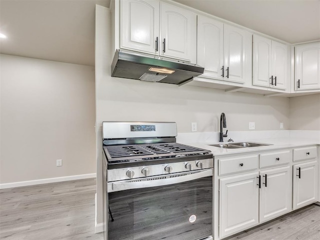 3609 S Quapah Ave, Oklahoma City, OK 73119 - kitchen featuring stainless steel gas range, under cabinet range hood, light wood-type flooring, white cabinets, and light countertops