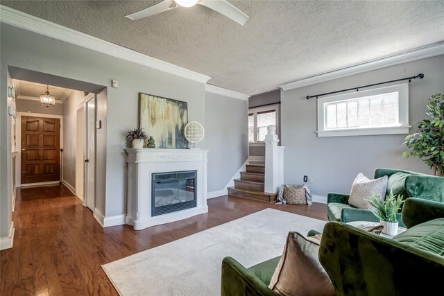 904 NW 19th St, Oklahoma City, OK 73106 - living room featuring ornamental molding, a glass covered fireplace, wood finished floors, a textured ceiling, and stairway
