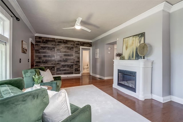 904 NW 19th St, Oklahoma City, OK 73106 - living area featuring an accent wall, wood finished floors, a glass covered fireplace, ceiling fan, and ornamental molding