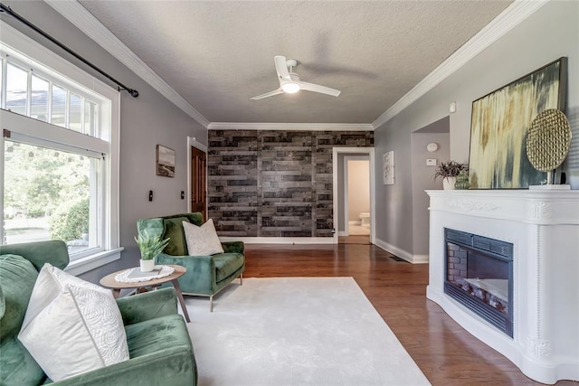 904 NW 19th St, Oklahoma City, OK 73106 - living area with wood finished floors, ceiling fan, a textured ceiling, an accent wall, and a glass covered fireplace