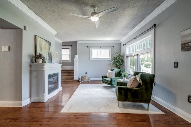 904 NW 19th St, Oklahoma City, OK 73106 - living area with crown molding, a ceiling fan, wood finished floors, a textured ceiling, and a glass covered fireplace