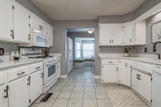 904 NW 19th St, Oklahoma City, OK 73106 - kitchen featuring white appliances, a ceiling fan, white cabinets, and a textured ceiling