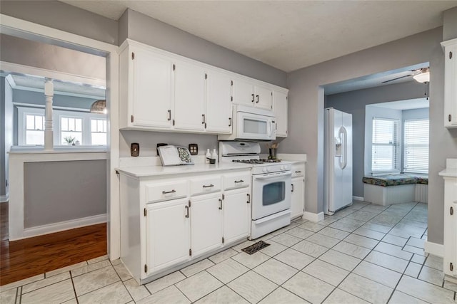 904 NW 19th St, Oklahoma City, OK 73106 - kitchen with white appliances, white cabinets, light countertops, light tile patterned floors, and a ceiling fan