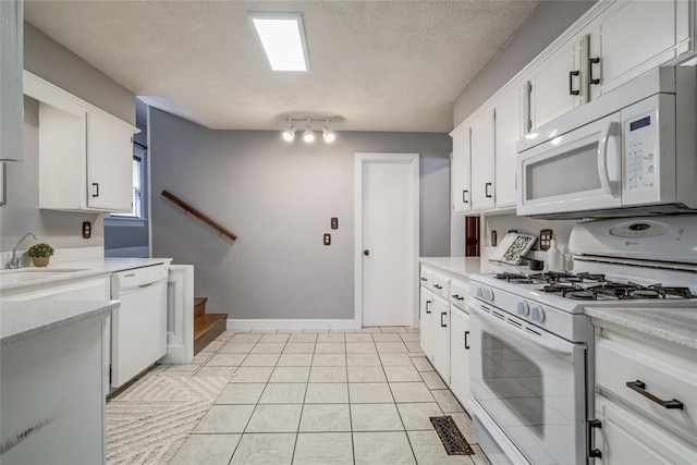 904 NW 19th St, Oklahoma City, OK 73106 - kitchen with white appliances, white cabinets, a textured ceiling, light tile patterned flooring, and light stone countertops