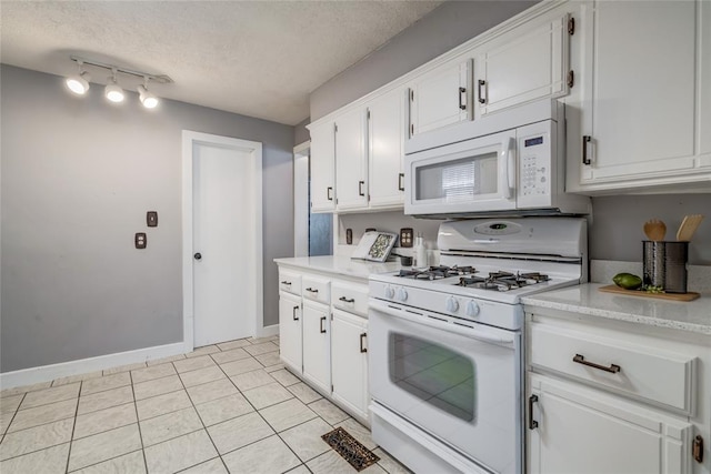 904 NW 19th St, Oklahoma City, OK 73106 - kitchen with white appliances, light countertops, a textured ceiling, white cabinets, and light tile patterned flooring