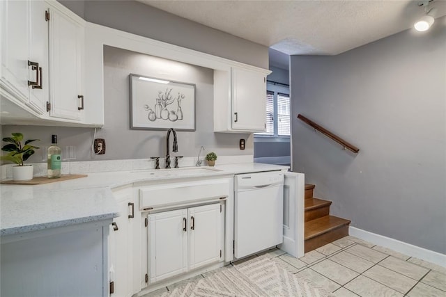 904 NW 19th St, Oklahoma City, OK 73106 - kitchen with white dishwasher, white cabinetry, light stone counters, a textured ceiling, and light tile patterned floors