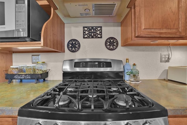 22071 E 1250th Rd, Rocky, OK 73661 - kitchen featuring stainless steel appliances, brown cabinetry, and range hood