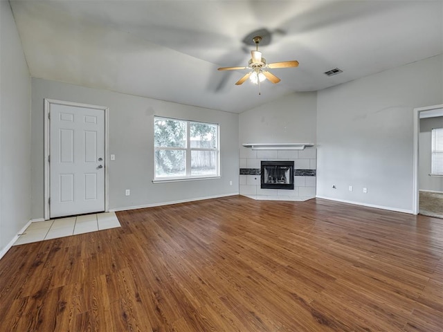 12300 NW 4th St, Yukon, OK 73099 - unfurnished living room featuring lofted ceiling, ceiling fan, wood finished floors, and a tile fireplace