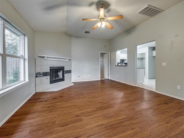 12300 NW 4th St, Yukon, OK 73099 - unfurnished living room with healthy amount of natural light, a fireplace, ceiling fan, wood finished floors, and lofted ceiling
