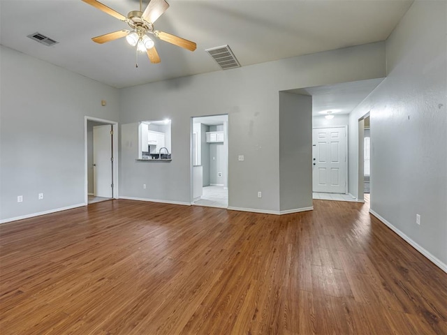12300 NW 4th St, Yukon, OK 73099 - unfurnished living room featuring wood finished floors and ceiling fan