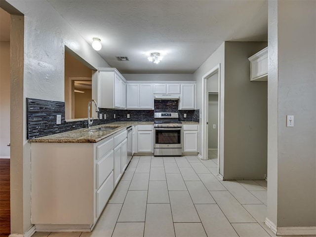 12300 NW 4th St, Yukon, OK 73099 - kitchen with stainless steel appliances, backsplash, white cabinetry, light stone counters, and light tile patterned floors