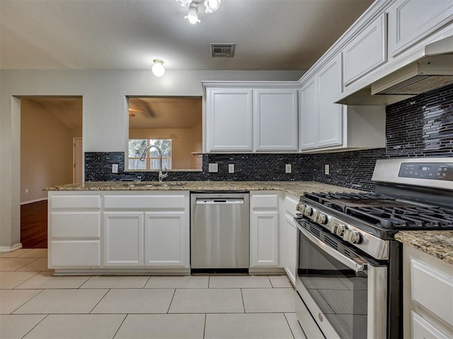 12300 NW 4th St, Yukon, OK 73099 - kitchen with appliances with stainless steel finishes, premium range hood, decorative backsplash, light tile patterned flooring, and white cabinetry