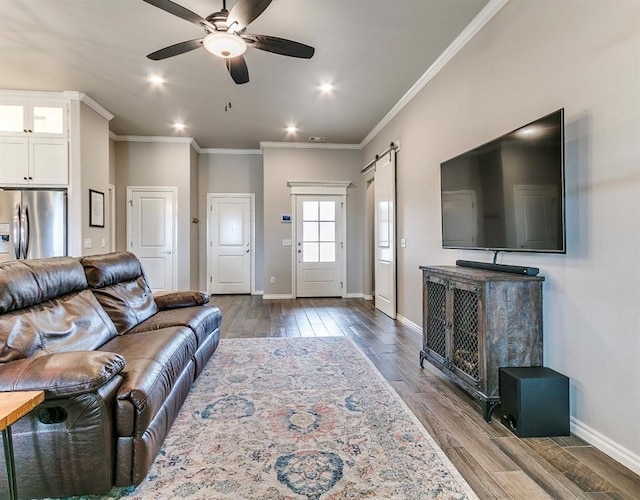 8401 Poplar Dr, Edmond, OK 73034 - living room featuring a barn door, wood finished floors, a ceiling fan, recessed lighting, and ornamental molding