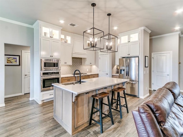 8401 Poplar Dr, Edmond, OK 73034 - kitchen featuring stainless steel appliances, crown molding, light countertops, a chandelier, and decorative backsplash