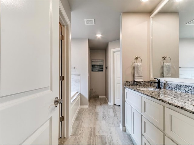 8401 Poplar Dr, Edmond, OK 73034 - full bath with vanity, a bath, marble look tile flooring, and recessed lighting
