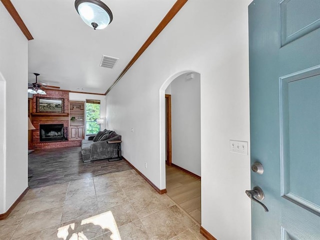 12200 Whispering Pnes, Guthrie, OK 73044 - entryway with arched walkways, ceiling fan, ornamental molding, a fireplace, and light tile patterned flooring