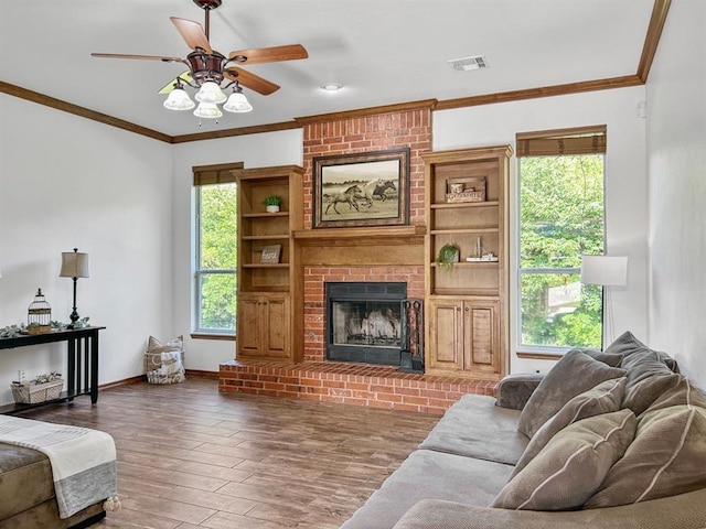 12200 Whispering Pnes, Guthrie, OK 73044 - living room with ceiling fan, wood finished floors, a fireplace, and crown molding