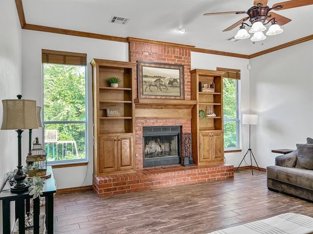 12200 Whispering Pnes, Guthrie, OK 73044 - living area featuring a ceiling fan, wood finished floors, crown molding, and a brick fireplace
