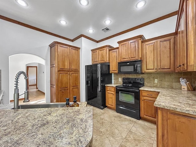 12200 Whispering Pnes, Guthrie, OK 73044 - kitchen with black appliances, brown cabinetry, arched walkways, crown molding, and decorative backsplash