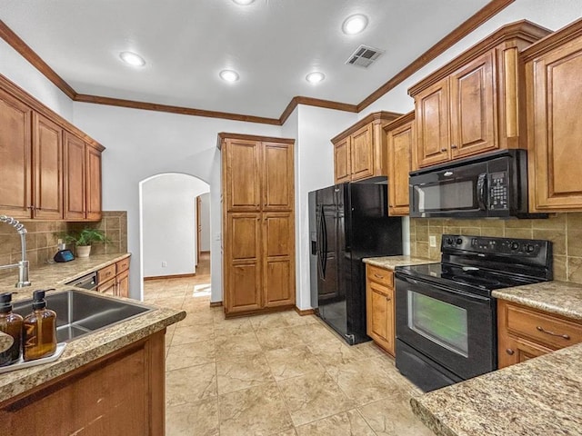12200 Whispering Pnes, Guthrie, OK 73044 - kitchen featuring black appliances, arched walkways, ornamental molding, brown cabinets, and tasteful backsplash