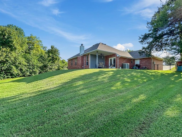 12200 Whispering Pnes, Guthrie, OK 73044 - back of house featuring brick siding, a chimney, and a lawn