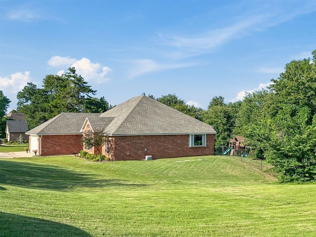 12200 Whispering Pnes, Guthrie, OK 73044 - view of home's exterior featuring a lawn, a playground, concrete driveway, and brick siding