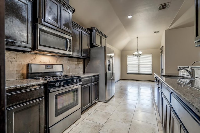 3904 Normandy Rd, Edmond, OK 73013 - kitchen featuring stainless steel appliances, a chandelier, backsplash, vaulted ceiling, and decorative light fixtures