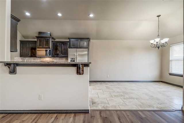 3904 Normandy Rd, Edmond, OK 73013 - kitchen featuring stainless steel appliances, a kitchen bar, a chandelier, dark brown cabinetry, and lofted ceiling