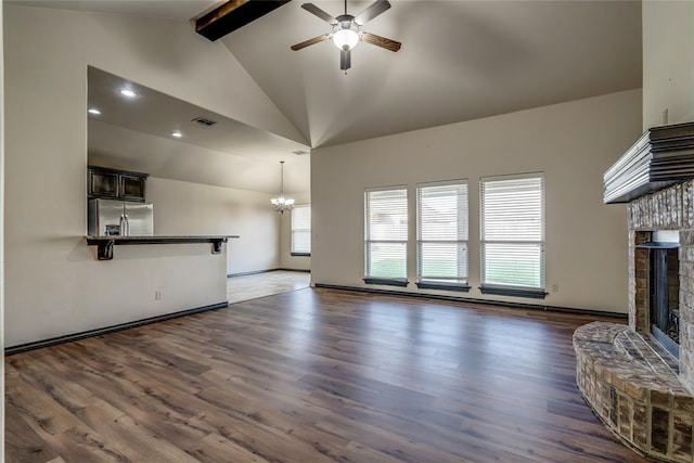 3904 Normandy Rd, Edmond, OK 73013 - unfurnished living room featuring a brick fireplace, a ceiling fan, beamed ceiling, a chandelier, and dark wood-type flooring