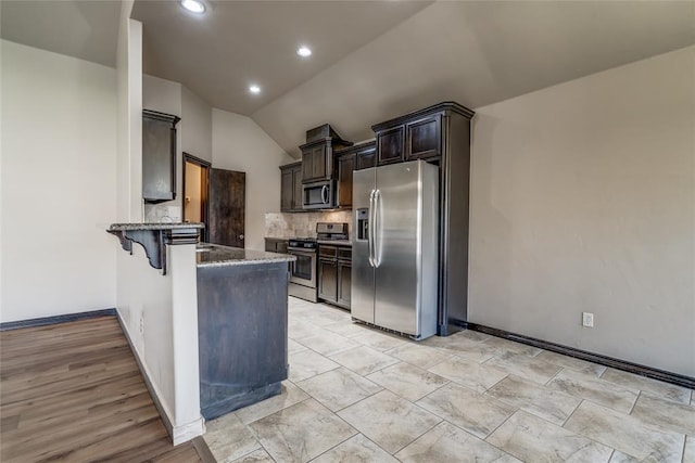 3904 Normandy Rd, Edmond, OK 73013 - kitchen featuring stainless steel appliances, dark stone countertops, decorative backsplash, a peninsula, and a breakfast bar area